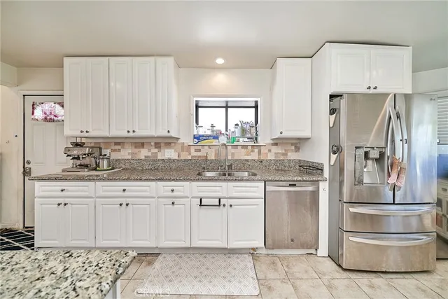 a kitchen with stainless steel appliances granite countertop a refrigerator sink and cabinets