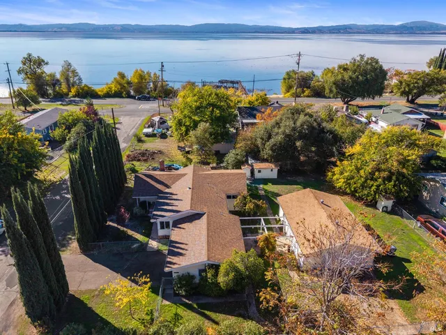 an aerial view of a house with a yard lake view and mountain view