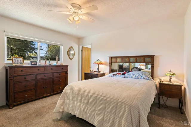 a bedroom with a bed and large windows
