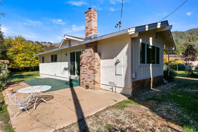 a view of a house with a yard and potted plants