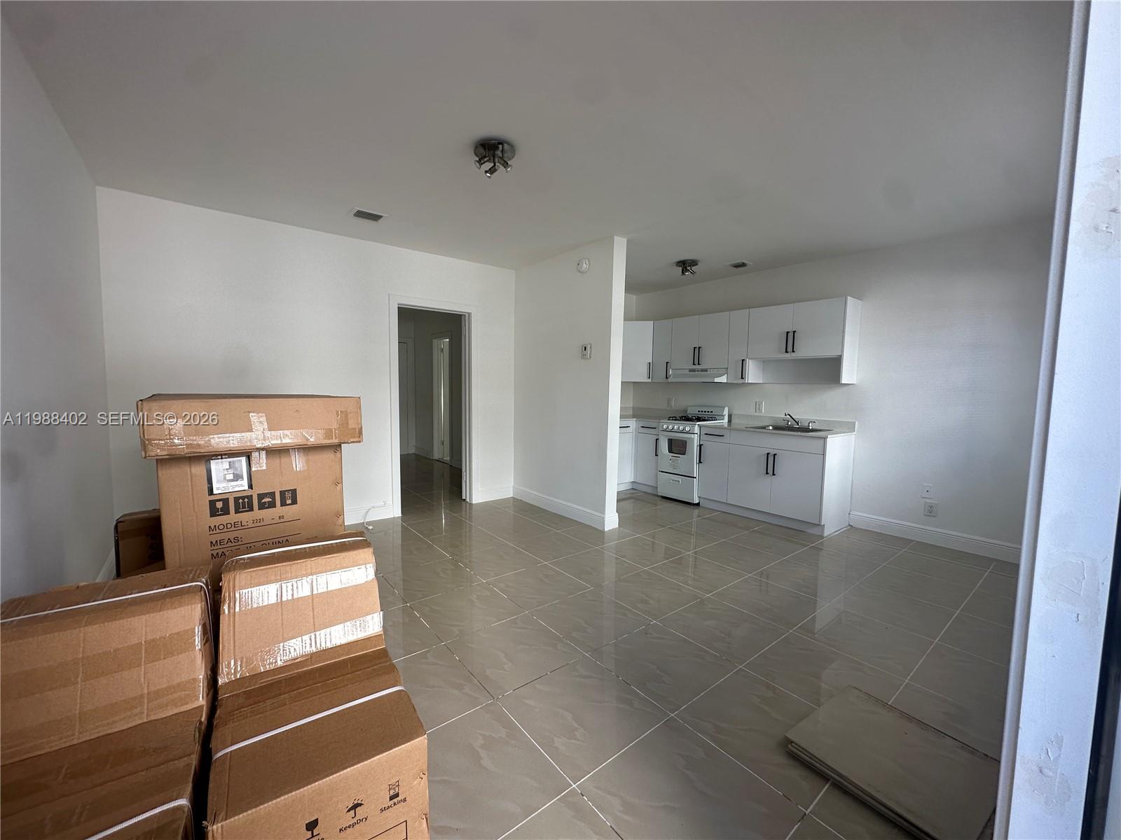 740 84th Street, Unit 3 Miami Beach, FL 33141 - Photo 8 of 12 a kitchen with stainless steel appliances a refrigerator and a stove