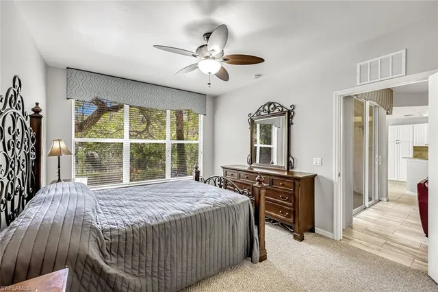 a bedroom with a bed and a large window with balcony view