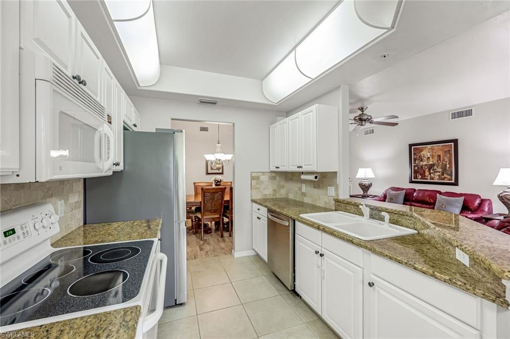 1345 Henley Street, Unit 706 Naples, FL 34105 - Photo 8 of 20 a kitchen with a stove sink and cabinets