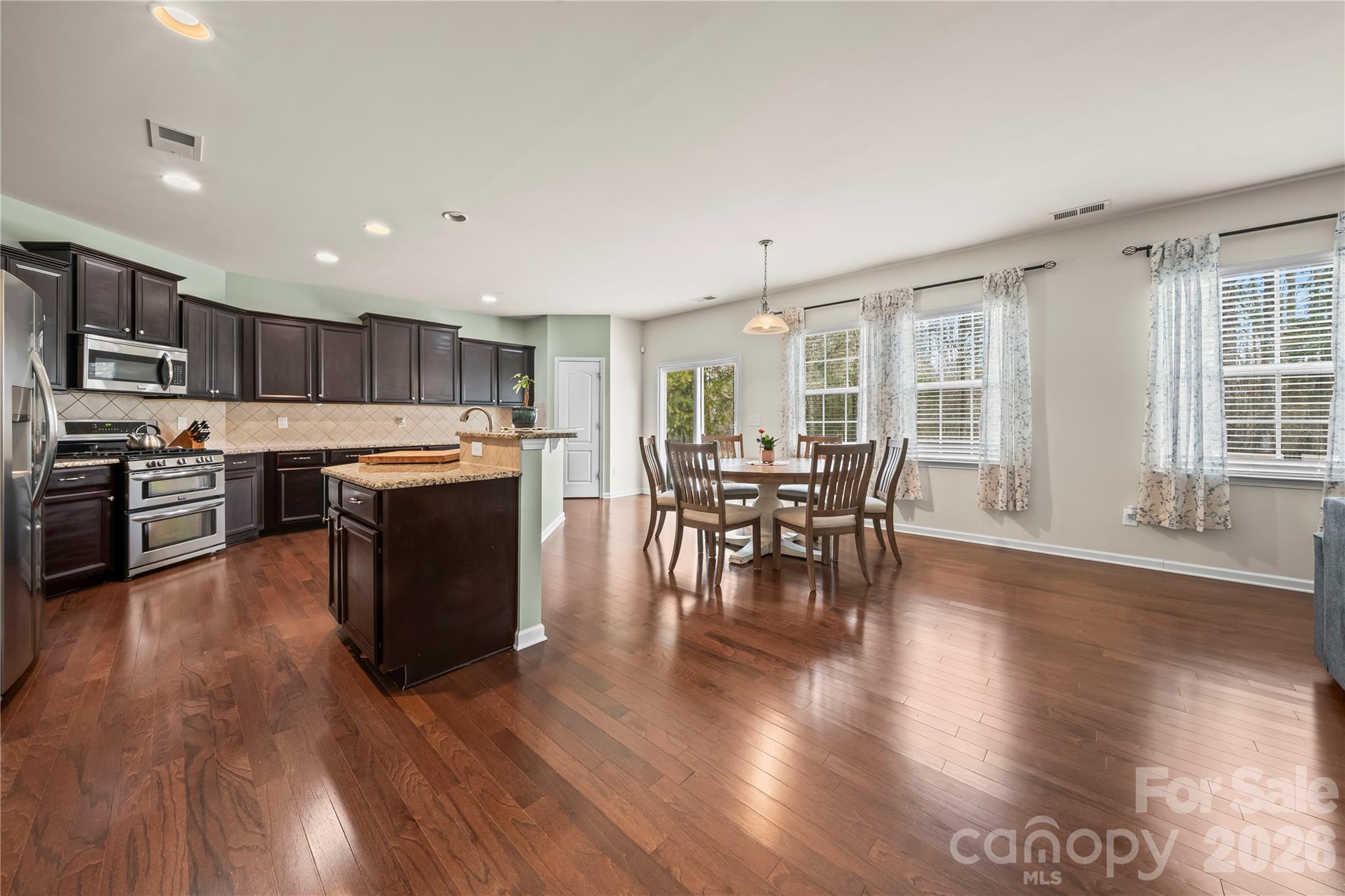 10666 Sapphire Trail Davidson, NC 28036 - Photo 12 of 34 a kitchen with stainless steel appliances wooden floors and wooden cabinets