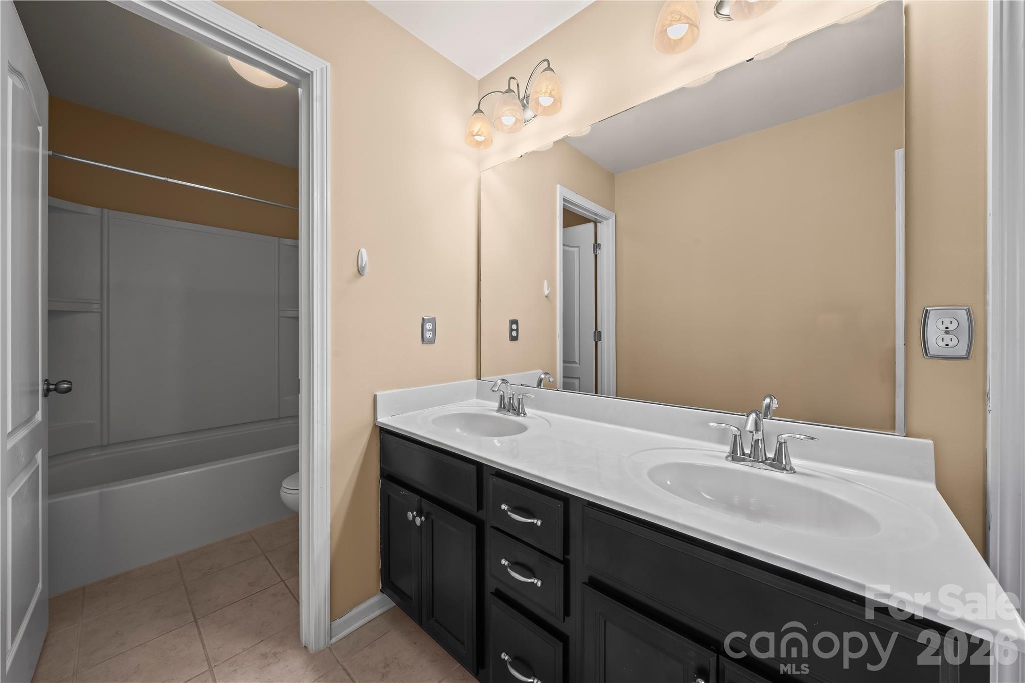 10666 Sapphire Trail Davidson, NC 28036 - Photo 26 of 34 a bathroom with a granite countertop sink a mirror and a bathtub