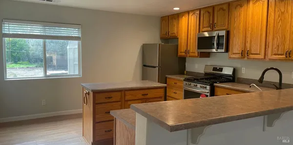 a kitchen with stainless steel appliances granite countertop a sink refrigerator stove and microwave
