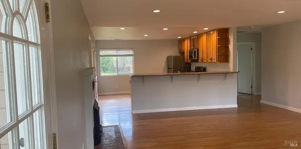 an empty room with wooden floor and a window