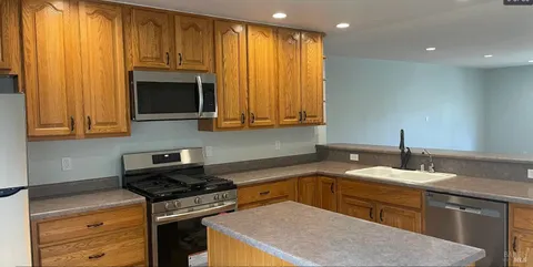 a kitchen with stainless steel appliances granite countertop a sink stove and cabinets