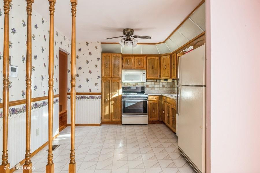 1349 North Dwiggins Street Griffith, IN 46319 - Photo 2 of 15 a kitchen with a refrigerator and white cabinets