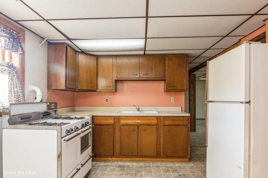 1349 North Dwiggins Street Griffith, IN 46319 - Photo 6 of 15 a kitchen with a sink a refrigerator and cabinets