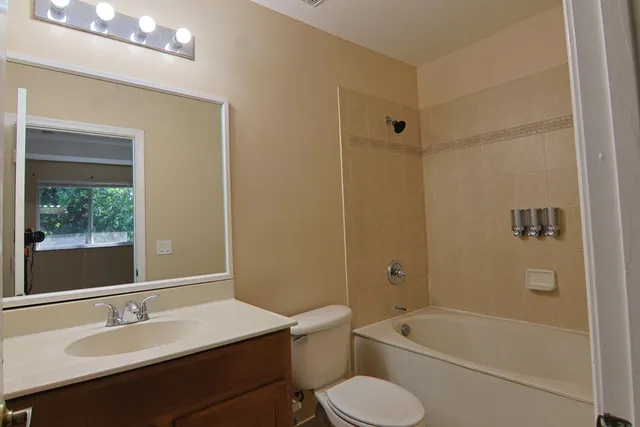 a bathroom with a granite countertop toilet a sink and a bathtub