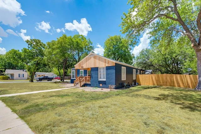 a view of a house with a yard and porch