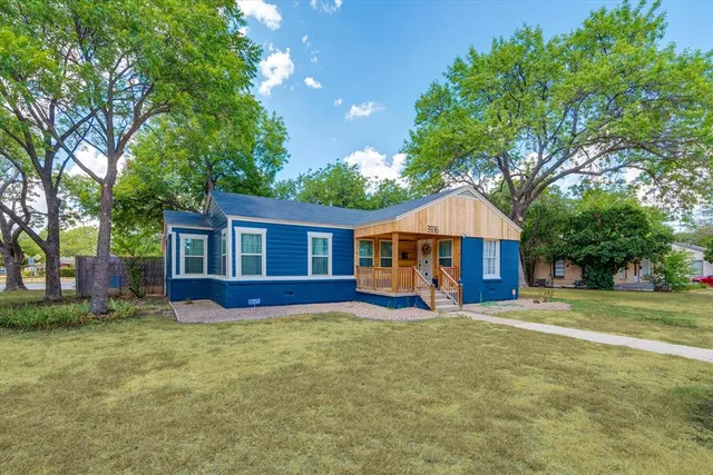 a view of a house with a yard and tree
