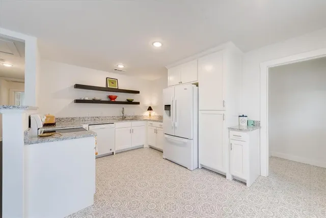 a kitchen with white cabinets and white appliances