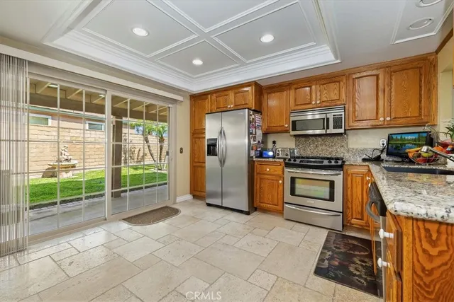 a kitchen with stainless steel appliances granite countertop a stove a sink and a refrigerator