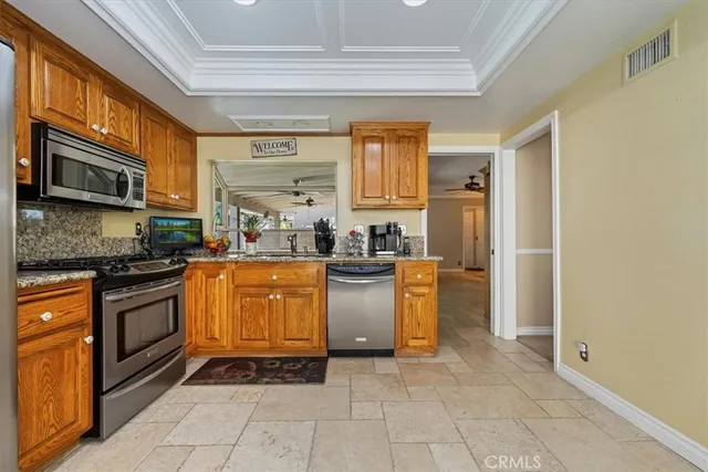 a kitchen with stainless steel appliances granite countertop a stove a sink and a refrigerator