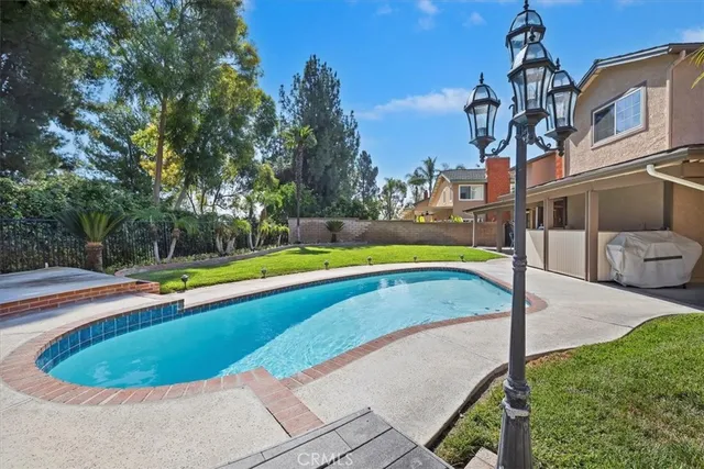 a view of a swimming pool with a yard and sitting area