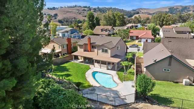 an aerial view of a house with a garden and outdoor seating