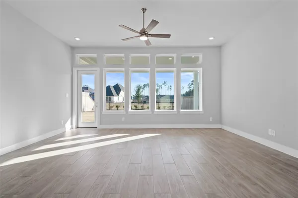 a view of a big room with wooden floor and a kitchen