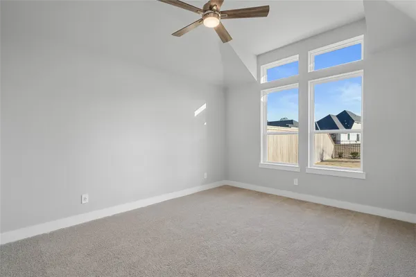 an empty room with a ceiling fan and closet area