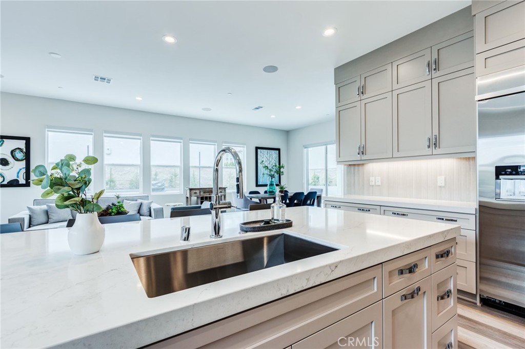 260 Holliston Lake Forest, CA 92630 - Photo 31 of 63 a kitchen with a sink dishwasher a stove and white cabinets with wooden floor