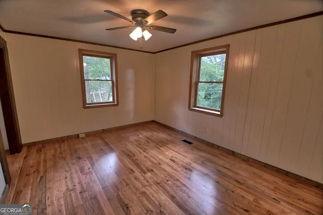 a view of an empty room window and wooden floor