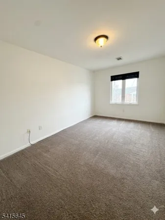 an empty room with a window and a ceiling fan