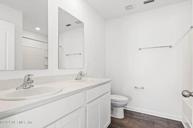 a bathroom with a granite countertop sink a toilet and a large mirror