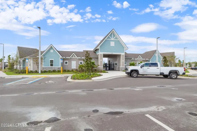 a view of a car parked in front of the house with a yard
