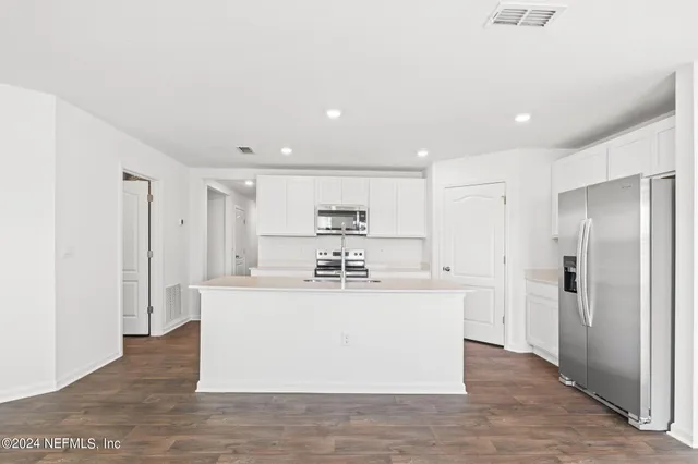 a large kitchen with stainless steel appliances a refrigerator and a stove