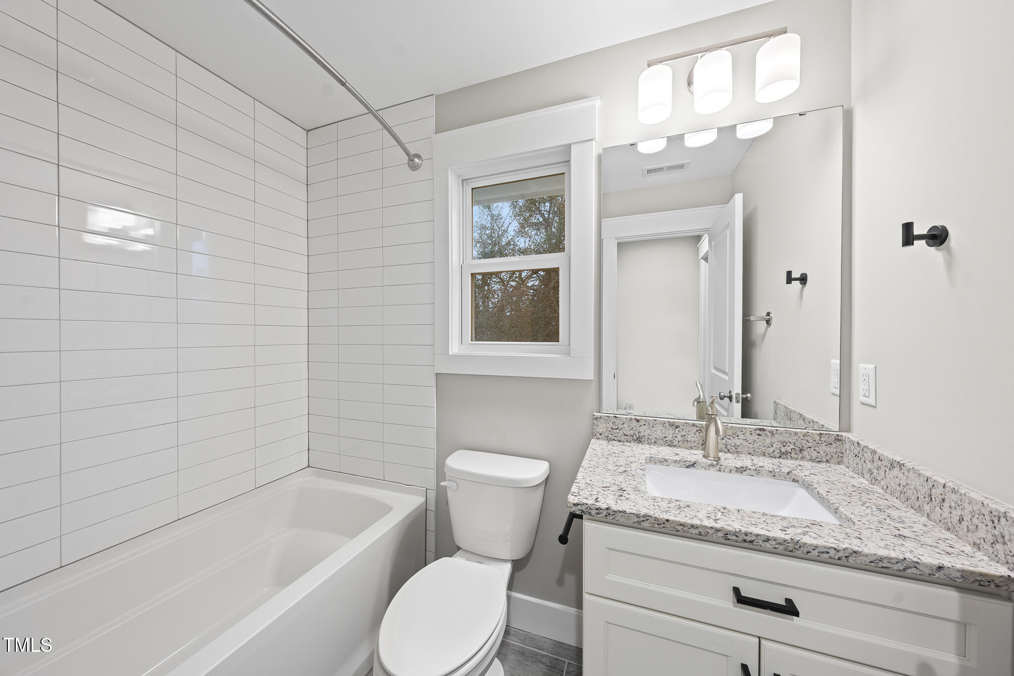 2717 Newbold Street Raleigh, NC 27603 - Photo 20 of 29 a bathroom with a granite countertop toilet a sink and bathtub