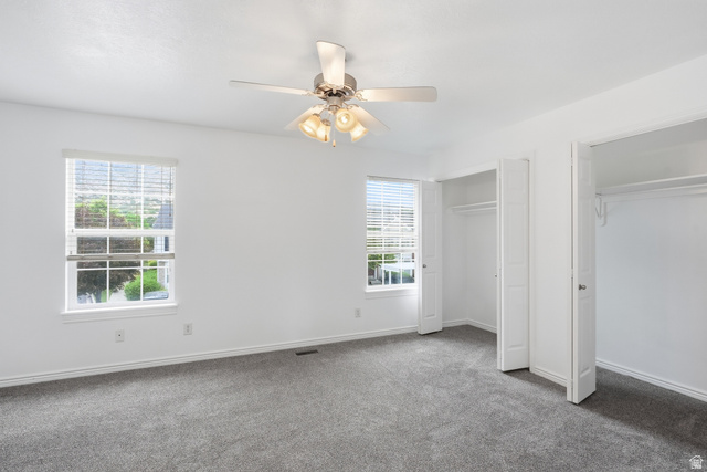 793 North 150 E Street Springville, UT 84663 - Photo 11 of 26 Light-filled room featuring plush gray carpeting, white walls, two window openings with blinds, a ceiling fan with integrated lighting, and two closet openings