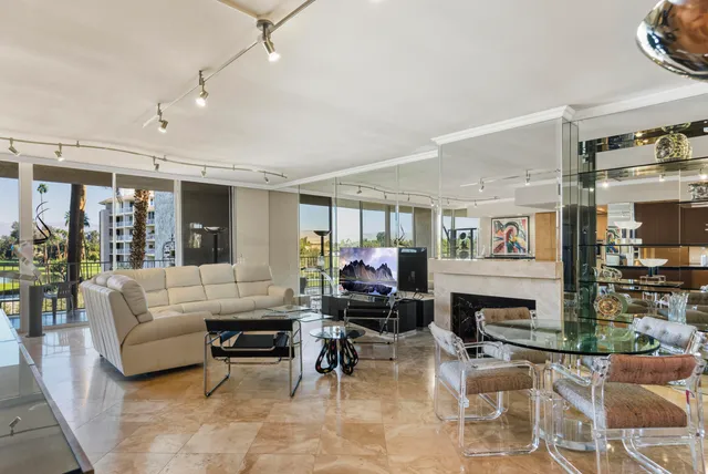 a living room with lots of furniture and a view of kitchen