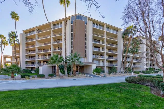 a view of a tennis ground with large trees