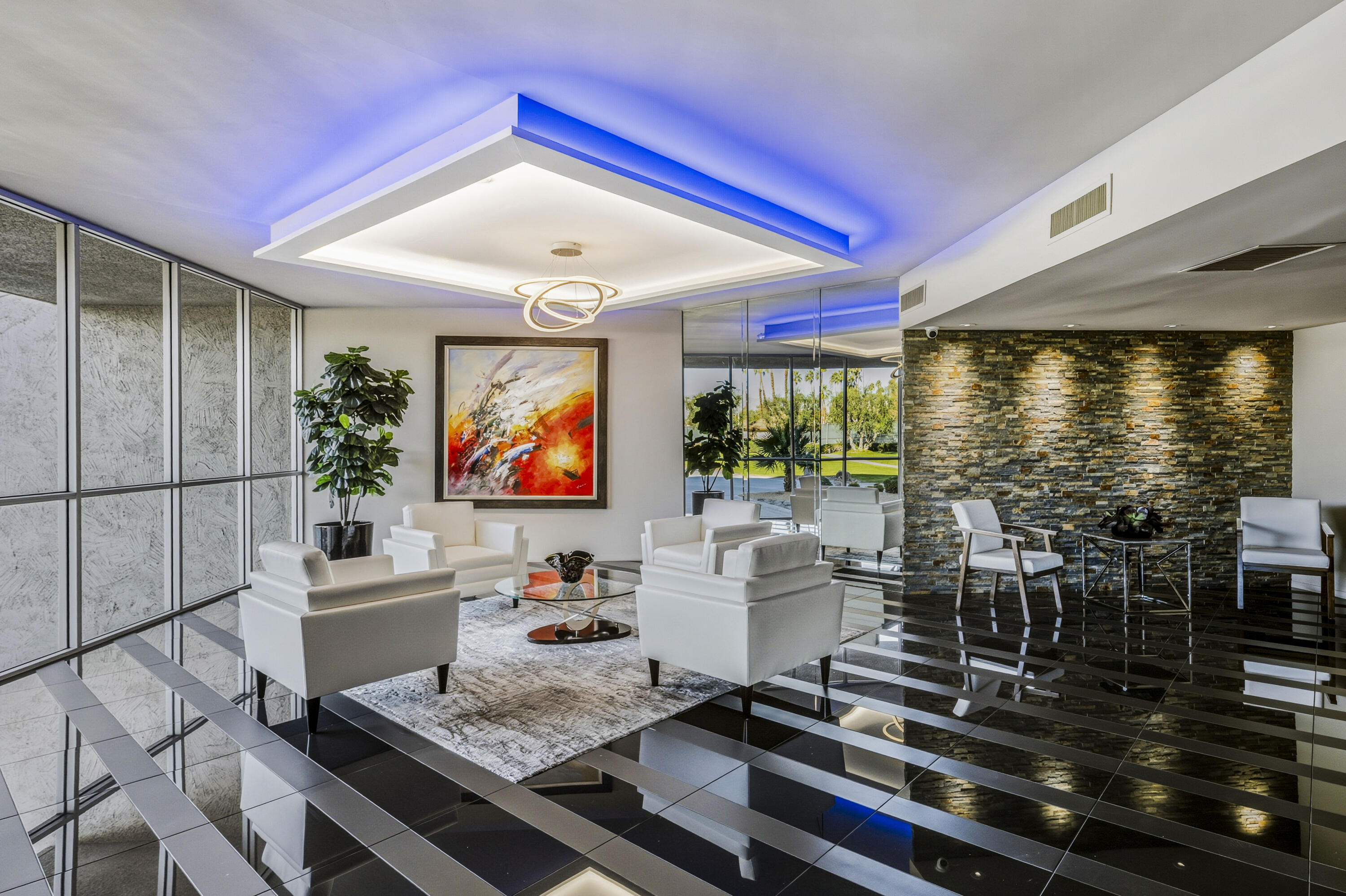 899 Island Drive, Unit 402 Rancho Mirage, CA 92270 - Photo 32 of 40 a living room with furniture flat screen tv and floor to ceiling window