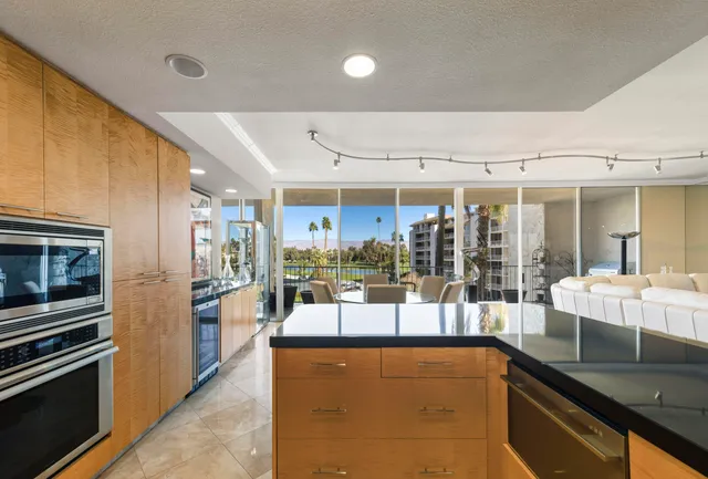 a kitchen with stainless steel appliances kitchen island granite countertop a table and chairs in it