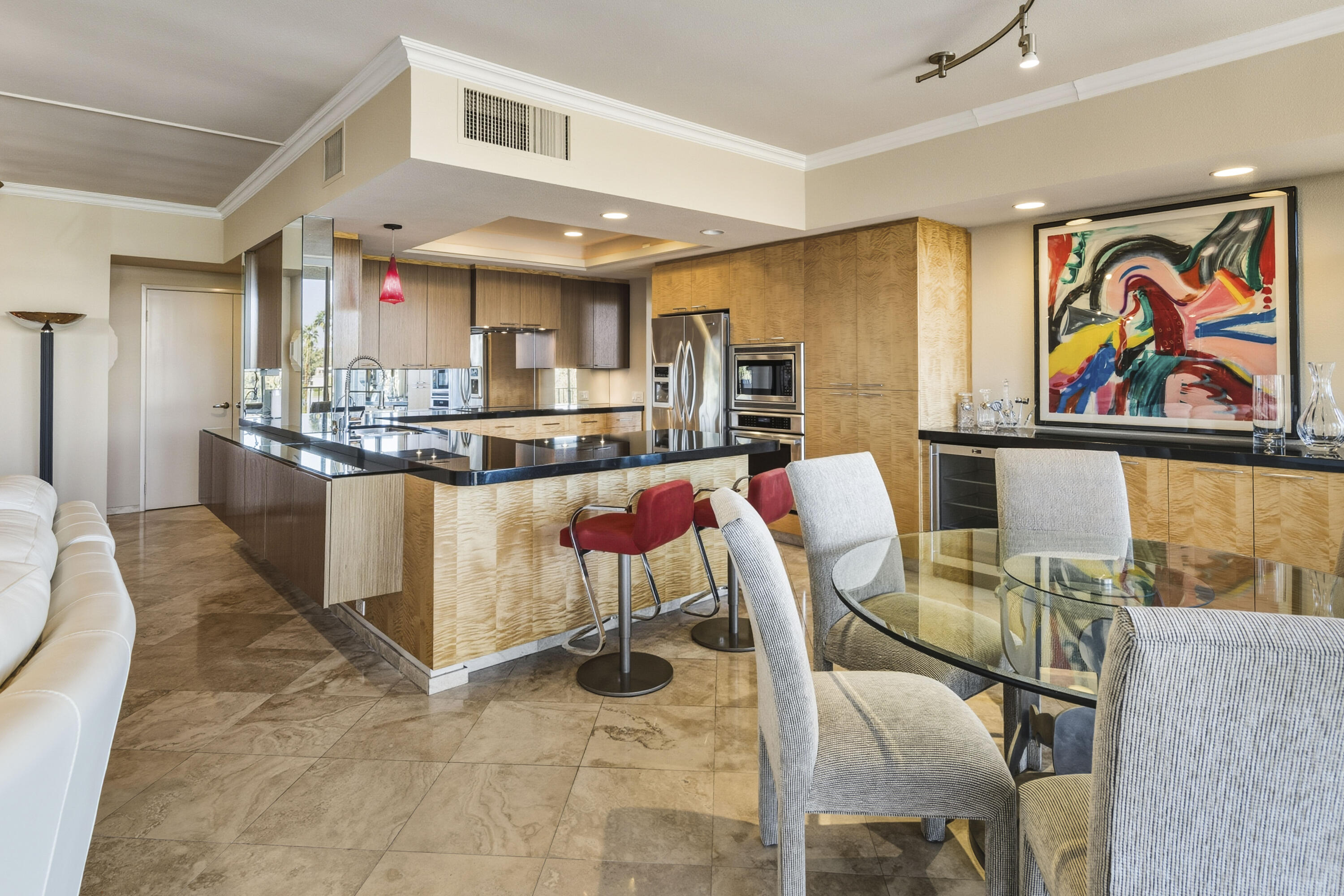 899 Island Drive, Unit 402 Rancho Mirage, CA 92270 - Photo 10 of 40 a kitchen with stainless steel appliances kitchen island granite countertop a table and chairs in it
