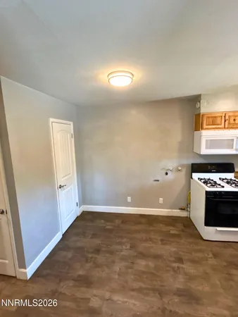 a view of kitchen with granite countertop cabinets and white appliances