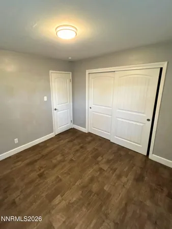an empty room with wooden door and mirror