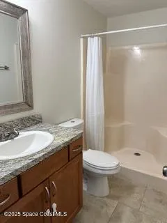 a bathroom with a granite countertop sink a toilet a mirror and shower