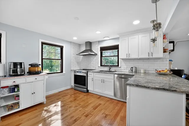 a large kitchen with stainless steel appliances lots of counter top space cabinets and a sink