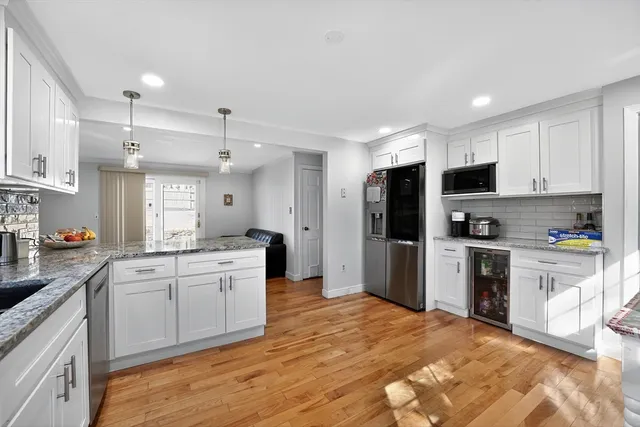 a large kitchen with stainless steel appliances granite countertop a stove a sink and a microwave