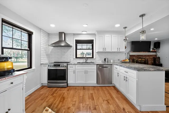 a kitchen with granite countertop a stove top oven a sink dishwasher and a refrigerator
