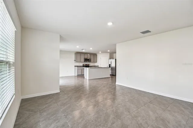 a view of kitchen with refrigerator and window