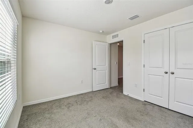 an empty room with windows and closet