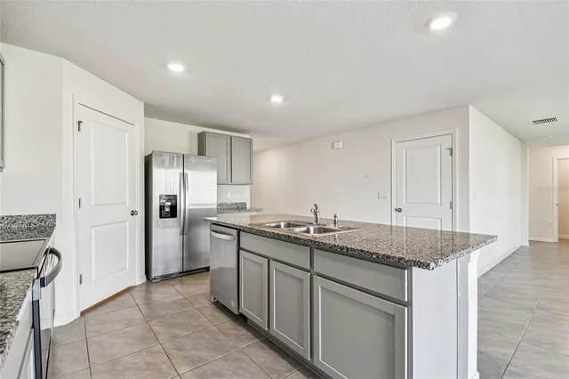 a kitchen with stainless steel appliances granite countertop a sink and a refrigerator