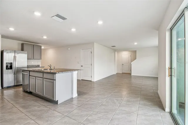 a kitchen with stainless steel appliances granite countertop a refrigerator and a sink