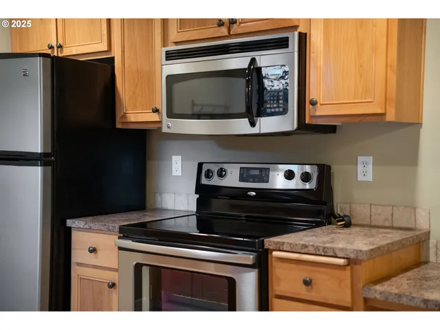 a kitchen with stainless steel appliances granite countertop a stove and a microwave