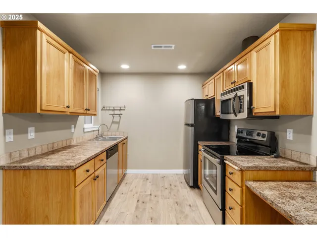 a kitchen with stainless steel appliances granite countertop a sink stove and refrigerator