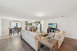 a living room with furniture and a wooden floor
